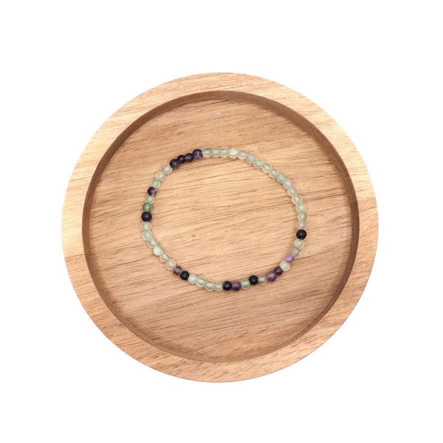 4 mm and 8 mm rainbow fluorite bracelets in wooden dish